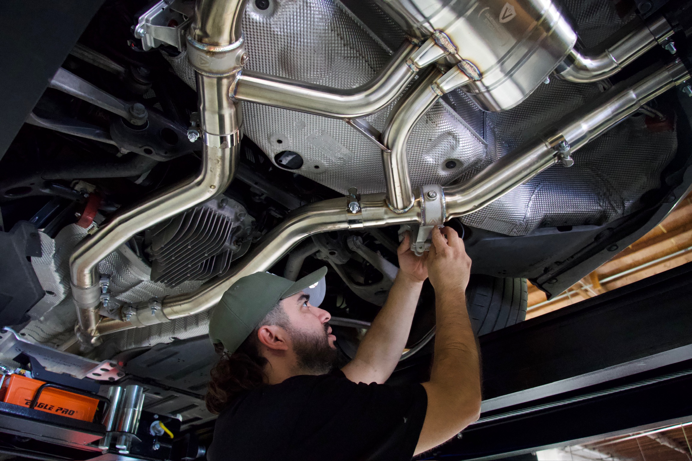 new port auto technician working on muffler